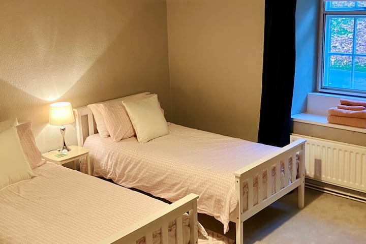 Prostrana dvokrevetna soba s bračnim krevetom (mogućnost prenamjene u super kralja) s toaletnim stolićem, ugradbenim ormarom i pogledom na centar Rothburyja.