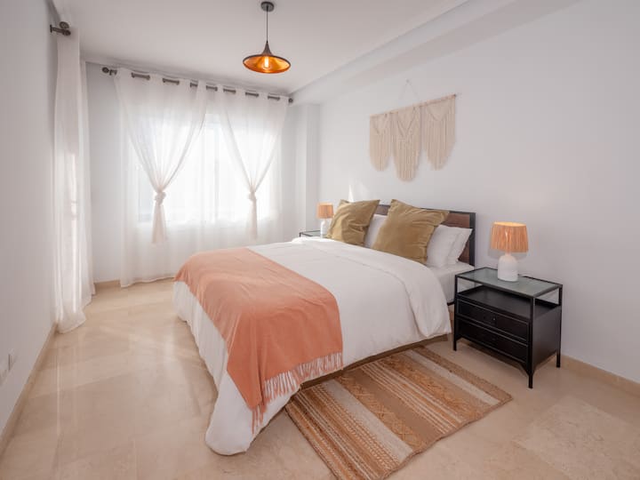 Hlavná spálňa je plná svetla a príjemná a ponúka manželskú posteľ s mäkkou posteľnou bielizňou, nočnými stolíkmi a štýlovou výzdobou. Relaxačný priestor na pokojné noci.