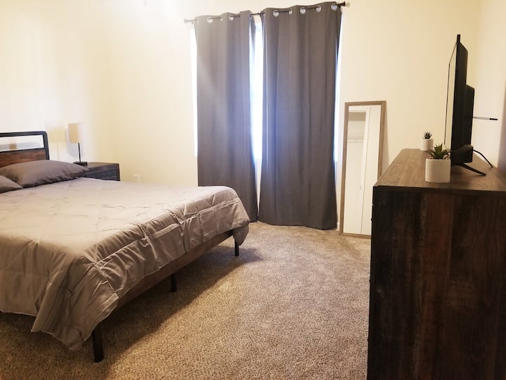 この居心地の良い快適なお部屋には、クイーンサイズのベッド、快適な睡眠のための遮光カーテン、ストリーミング用のスマートテレビ、全身ミラーが備わっています。ベッドサイドにはコンセントが内蔵されたモダンなタッチランプがあり、お使いのデバイスを簡単に充電できます。