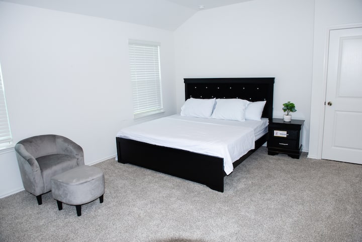 Opustite se u prostranoj glavnoj spavaćoj sobi s mekanom posteljinom i mirnim ambijentom koji je ispunjen sunčevom svjetlošću.