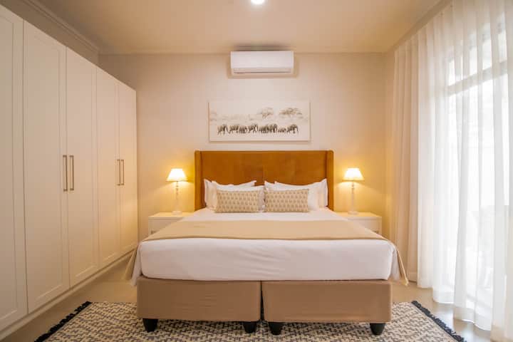 חדר שינה ראשי מרווח ונעים עם יחידת מיזוג אוויר ומאוורר.