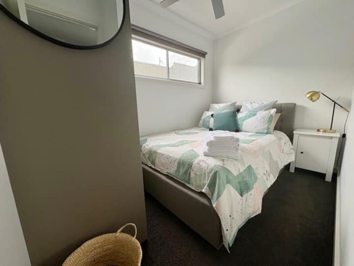 ห้องนอนที่อบอุ่นพร้อมเตียงควีนไซส์ติดตั้งผ้าฝ้ายอียิปต์ม่านบังมู่ลี่พัดลมเพดานเสื้อคลุมขนาดใหญ่พร้อมพื้นที่สำหรับแขวนและพับเสื้อผ้าทีวีติดผนัง