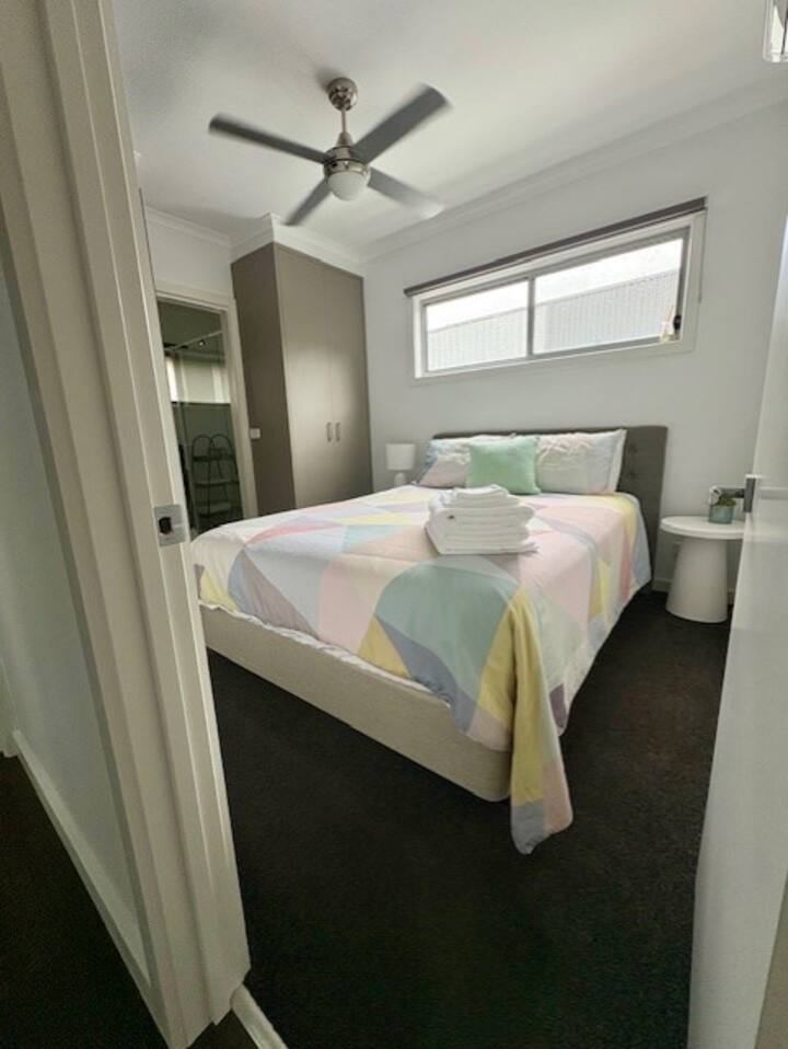 ห้องนอนใหญ่ที่อบอุ่นพร้อมเตียงควีนไซส์ที่ติดตั้งผ้าฝ้ายอียิปต์บล็อคมู่ลี่พัดลมเพดานเครื่องปรับอากาศเสื้อคลุมขนาดใหญ่คู่พร้อมพื้นที่สำหรับแขวนและพับเสื้อผ้า ทีวีติดผนังห้องน้ำในตัวเต็มรูปแบบส่วนตัวติดกัน