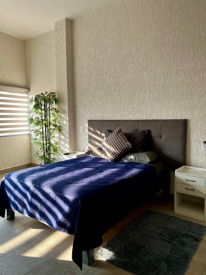 Chambre principale équipée de la climatisation, d'une télévision, d'un espace de travail et d'un grand placard pour votre confort.