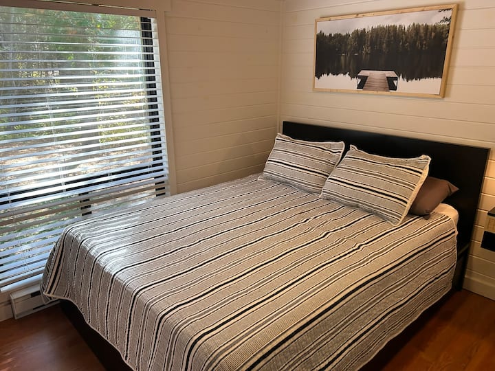 Spálňa 3 s manželskou posteľou Queen.  Plávajúce nočné stojany a malý šatník.