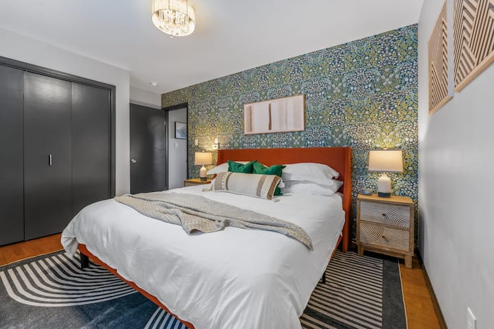 Cette chambre spacieuse dispose d'un lit king size luxueux, vous invitant à vous ressourcer avec style. Le papier peint animé et la décoration chic créent une ambiance accueillante. Parfaite pour la détente, cette chambre est une véritable retraite.