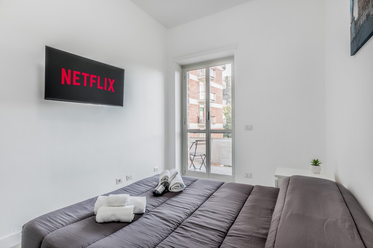 Dormitorio espacioso y cómodo con TV inteligente y Netflix gratuito. Cómoda cama cuadrada y media y vista al paisaje urbano.