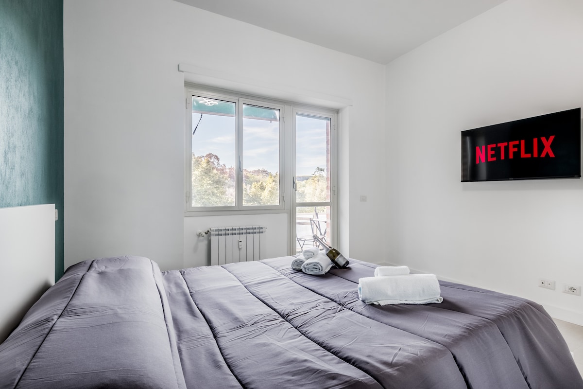 Dormitorio espacioso y cómodo con TV inteligente y Netflix gratuito. Cómoda cama doble y vista al paisaje urbano.
