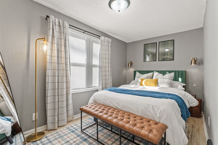 Bedroom 2 welcomes you with sunny windows and a plush queen bed, creating a bright and cozy retreat for relaxation.