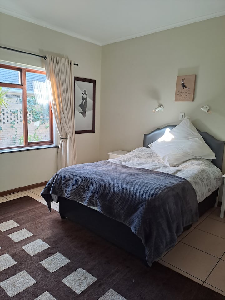 Chumba cha kulala chenye nafasi kubwa, chenye jua, chenye kitanda cha watu wawili na dawati dogo. 