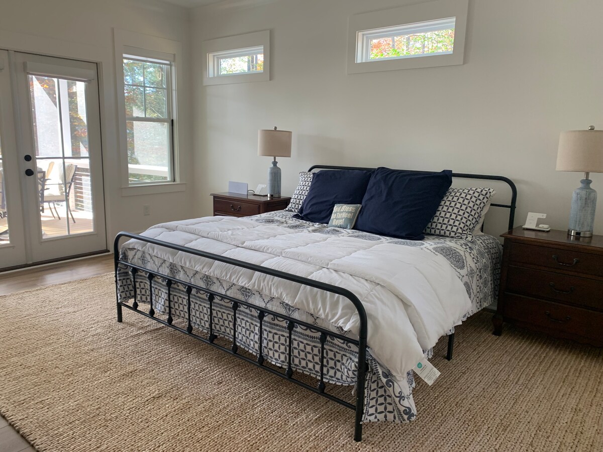 Dhomë gjumi e madhe kryesore me krevat dopio "king", banjë ngjitur me dush, hyrje në verandë dhe pamje të bukur të liqenit.