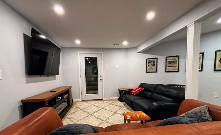 تحتوي غرفة المعيشة المريحة في الطابق السفلي على تلفزيون كبير مثبت على الحائط ومدفأة كهربائية أنيقة لمزيد من الأجواء ومقاعد مريحة مع سرير أريكة جلدي كبير وأريكة جلدية.  مثالية للاسترخاء أو مشاهدة الأفلام أو الاستمتاع بلحظات هادئة.