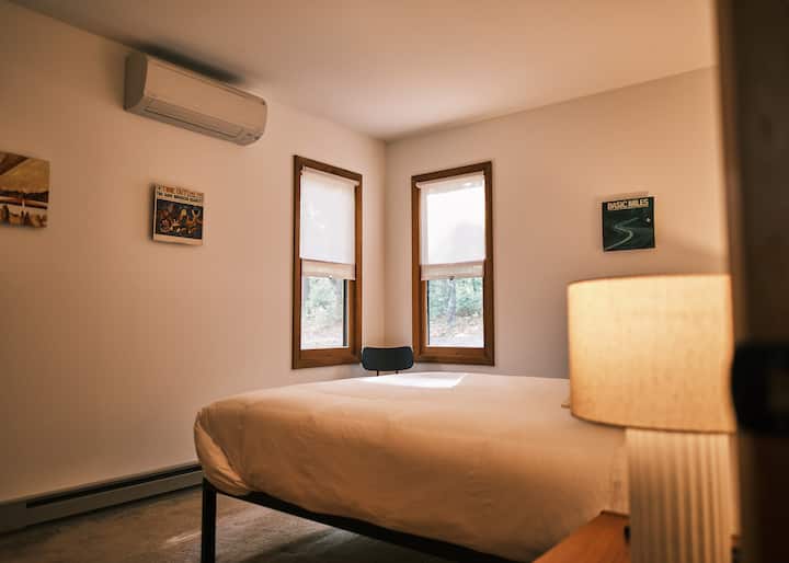 One of two cozy downstairs bedrooms, with queen-sized bed, 400 thread count sheets, premium pillows, and vintage teak night stands. 