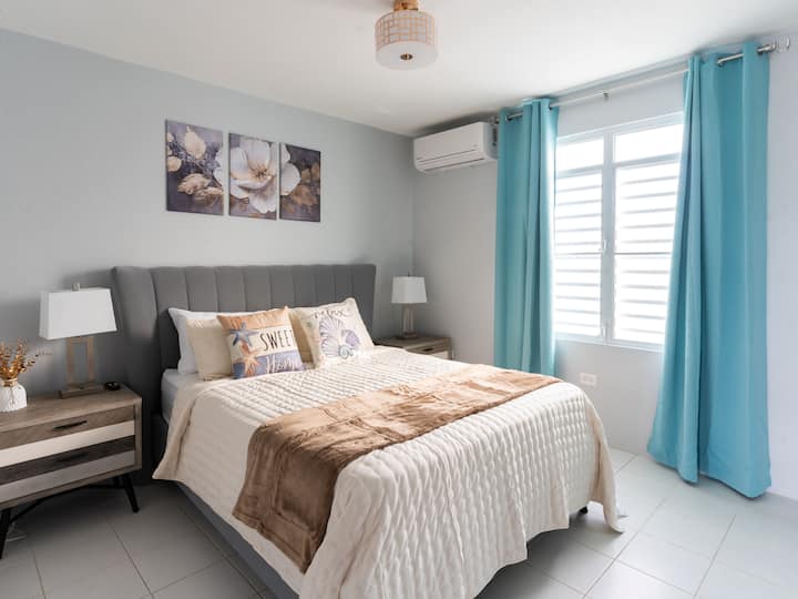 Dormitorio principal con aire acondicionado, TV de 55pulgadas, armario y baño adjunto.