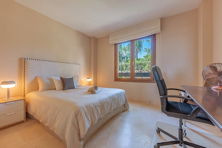 Druhá spálňa s manželskou posteľou, vyhradeným pracovným priestorom a vstavanými skriňami.