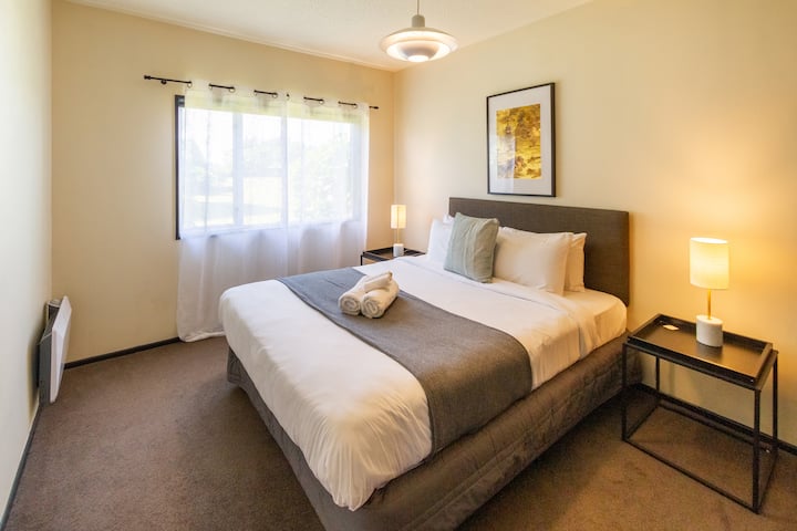 Stijlvolle slaapkamer met ontspannend bed, fris beddengoed en zachte kussens