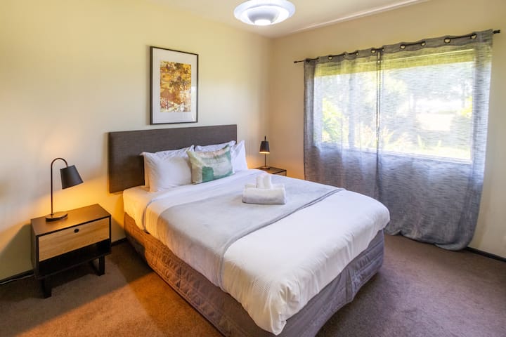 Stijlvolle slaapkamer met ontspannend bed, fris beddengoed en zachte kussens