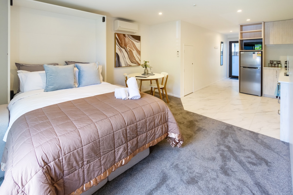 Udoban kauč na razvlačenje s hrskavom posteljinom, plišanim jastucima, mekim dekama i ukrasnim ukrasnim jastucima