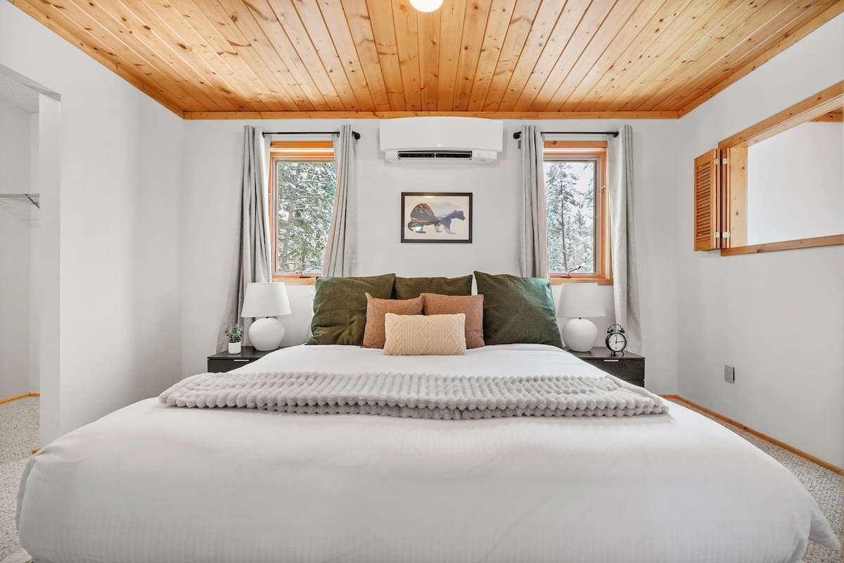 キングサイズのベッド、クローゼット、遮光カーテンを備えた最上階のメインベッドルーム。