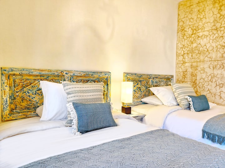 Habitación con 2 camas individuales, baño privado que comparte para visitas.