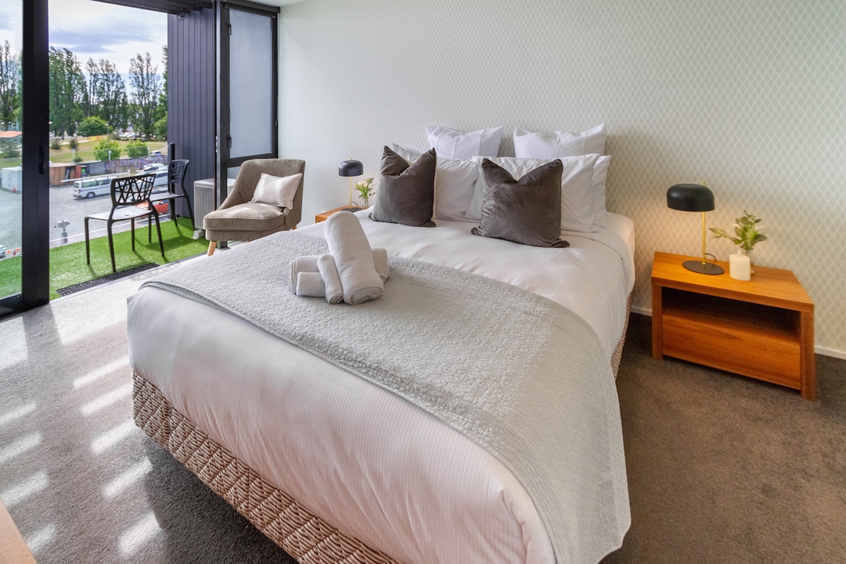 Lujosa cama tamaño queen con ropa de cama cómoda y sábanas de hotel de 5 estrellas.