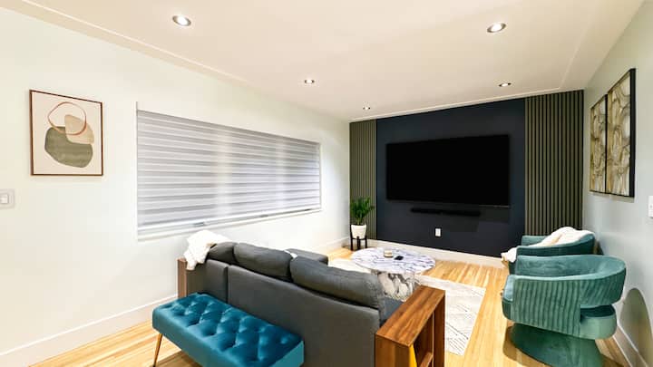 غرفة معيشة بسرير أريكة وتلفزيون 85 بوصة