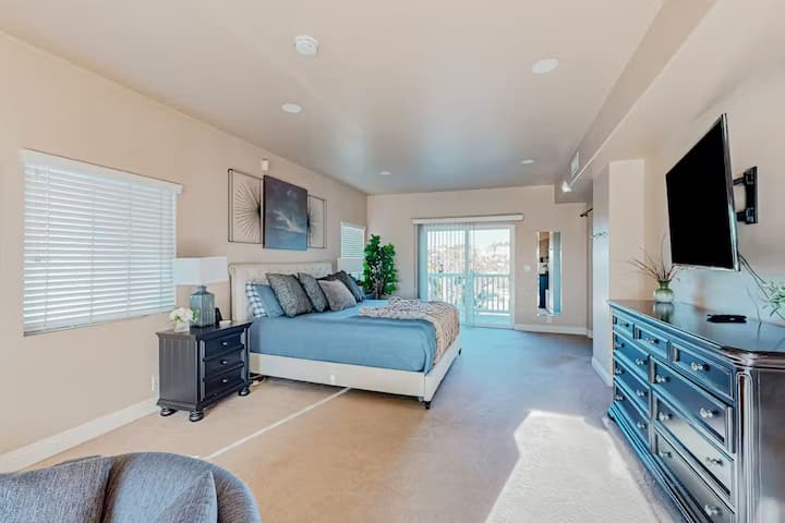 Просторна родителска спалня с плюшено двойно легло, елегантен телевизор, монтиран на стената, луксозен скрин и самостоятелен балкон. Това спокойно място за отдих предлага комфорт, стил и идеалното място да се отпуснете и да се насладите на гледките.