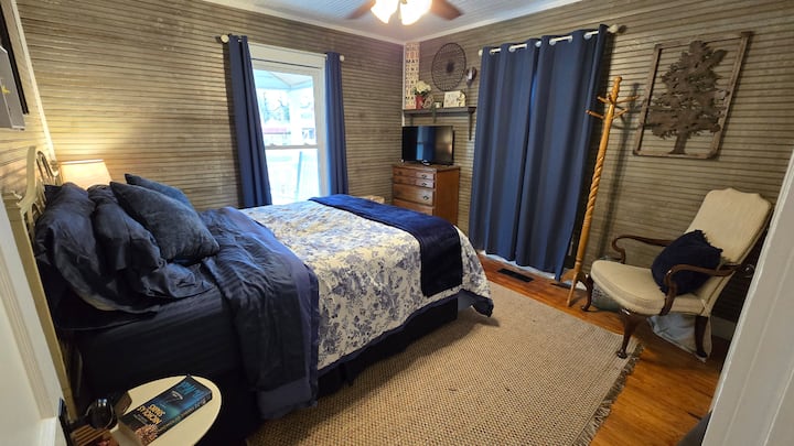 El dormitorio de invitados cuenta con una cama tamaño queen, TV, almacenamiento y sala de estar.