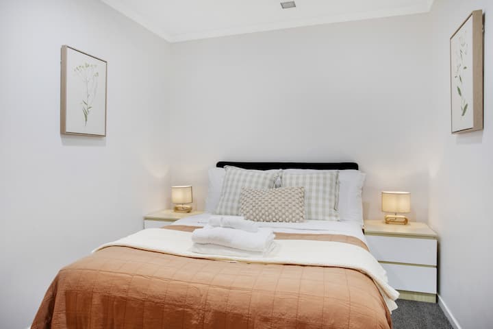 Na ovom bračnom krevetu nalaze se hrskave bijele plahte i šarena navlaka.