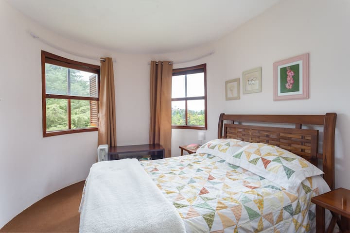 Stora fönster tillåter ingången av naturligt ljus in i sviten, och erbjuder utsikt mot den omgivande vegetationen. Perfekt för par som söker lugn och komfort, har sovrummet en rymlig dubbelsäng med nya sängkläder av hög kvalitet.
