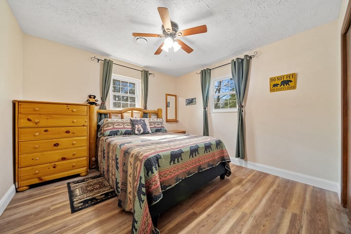 מיטת קווין סייז עם וילונות האפלה, שידת לילה, שידה גדולה, מראה, מאוורר תקרה, 2 חלונות עם נופים מרהיבים וארון.