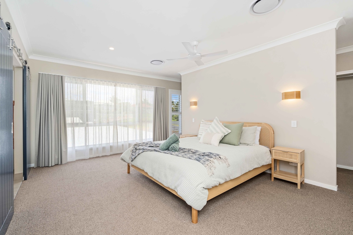 חדר השינה הראשי ממוקם למעלה וכולל מיטת קינג-סייז, מזגן, חדר הלבשה, מראה בגובה מלא, וילונות שקופים ושחורים, טלוויזיה חכמה 45 אינץ' וחדר רחצה ענק.