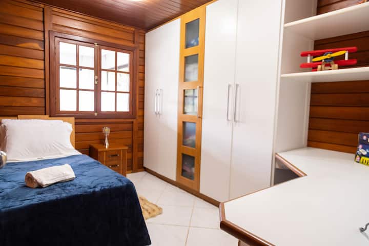 חדר שינה יחיד עם מיטת עזר ופינת עבודה