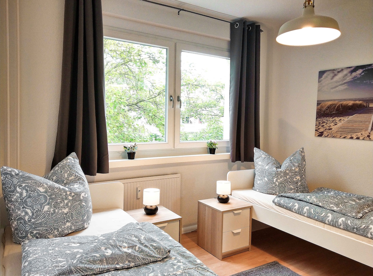 Udobna spavaća soba s dva kreveta za jednu osobu i dva ormara.