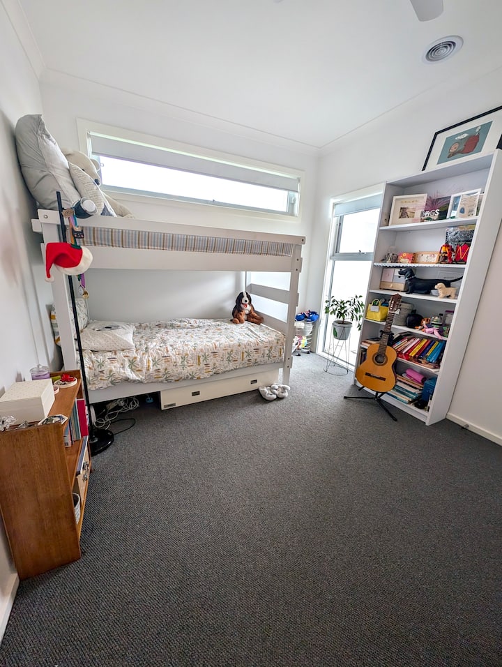 Chumba cha kulala cha watoto chenye vitanda vya ghorofa na vitabu vingi, michezo, mafumbo ya kuwafanya wawe na shughuli