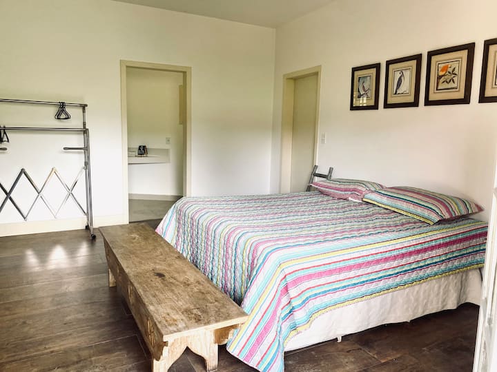 Suite , dormitorio con cama tamaño king y baño .