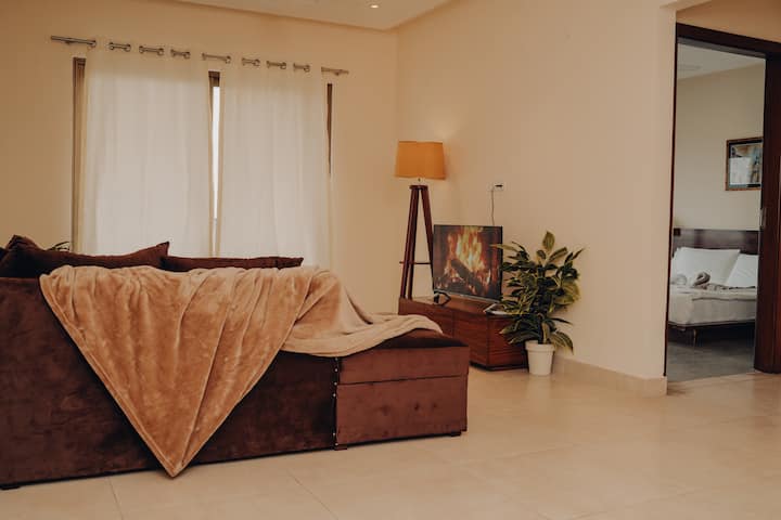 غرفة المعيشة هي ملاذ مريح مع أرائك مرتبة حول تلفزيون بشاشة مسطحة أنيقة، مثالية للاسترخاء. تتوفر أيضًا مجموعة مختارة من مواد القراءة والكتب وهي مثالية لمحبي الكتب. 