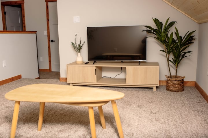 Televizor me ekran të sheshtë për të transmetuar shfaqjen ose filmin tënd të preferuar! Lojërat dhe librat për të gjitha moshat ndodhen në stendën e televizorit për argëtim pa ekran.