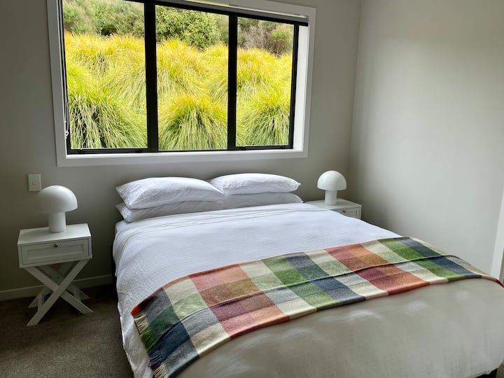 Тази спокойна спалня разполага с двойно легло с меко спално бельо и цветно легло. Големите прозорци предлагат спокойна гледка към градината, а просторният килер осигурява достатъчно място за съхранение на релаксиращ и комфортен престой.