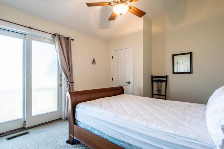 Dormitorio con cama tamaño queen y baño compartido