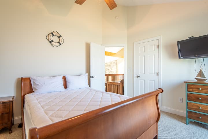 Dormitorio con cama tamaño queen y baño compartido