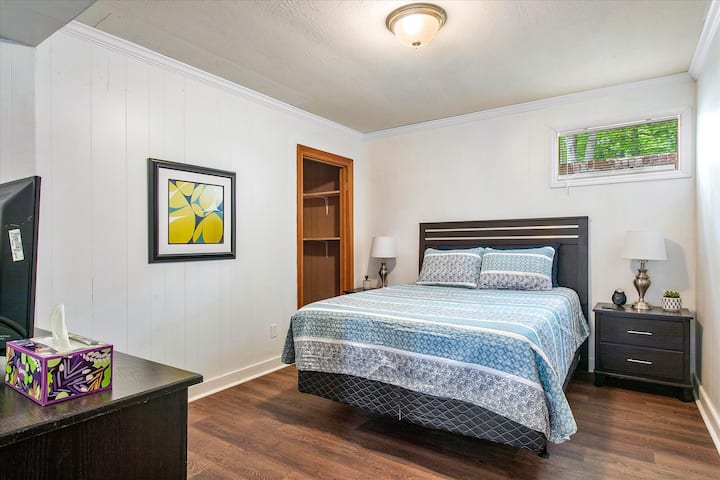 Third bedroom in basement with closet space, flat-screen Roku TV and queen bed.