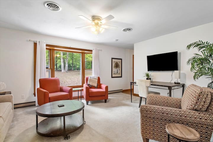 Upper floor living room with ample seating, tons of natural lighting, flat-screen Roku TV, pull out queen size sofa bed and desk workspace.