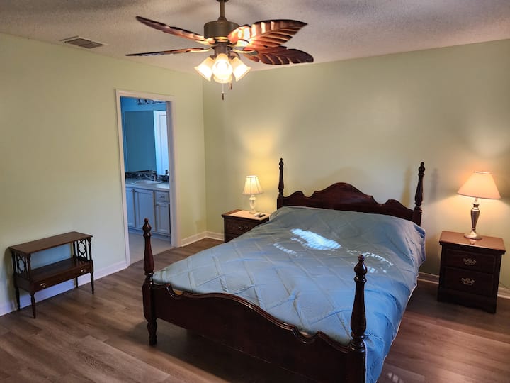 Veľká manželská posteľ, šatníková skriňa, vlastná kúpeľňa s toaletou, televízor s plochou obrazovkou a stropný ventilátor.