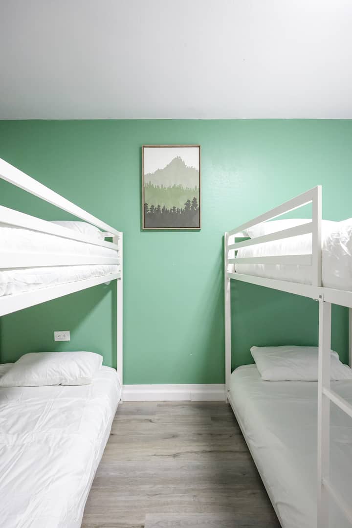 Una elegante habitación con literas que ofrece 6 cómodas camas individuales para tu estancia.