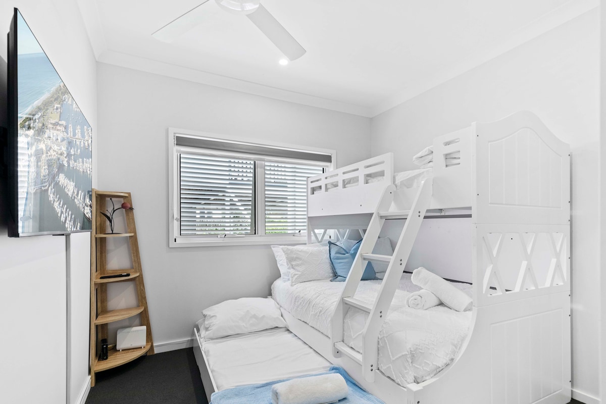 Chumba cha kulala chenye mwanga na kinachofaa kwa watoto chenye kitanda cha ghorofa na kitanda kinachotolewa, runinga ya skrini bapa, feni ya dari na rafu ya kona.