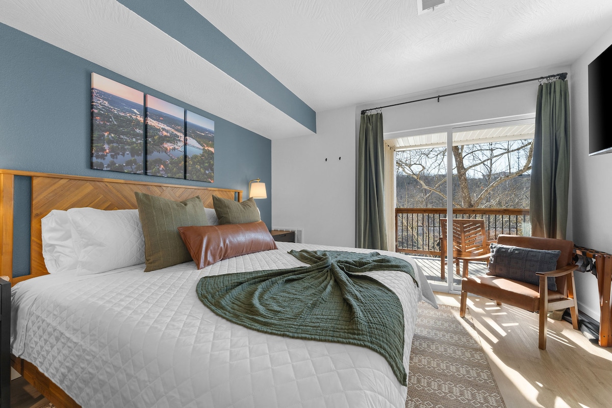 Chambre confortable avec un cadre de lit en bois élégant, des oreillers doux et un accès à un balcon pittoresque. Une télévision 4K, un bureau et Pack & Play sont à votre disposition. 