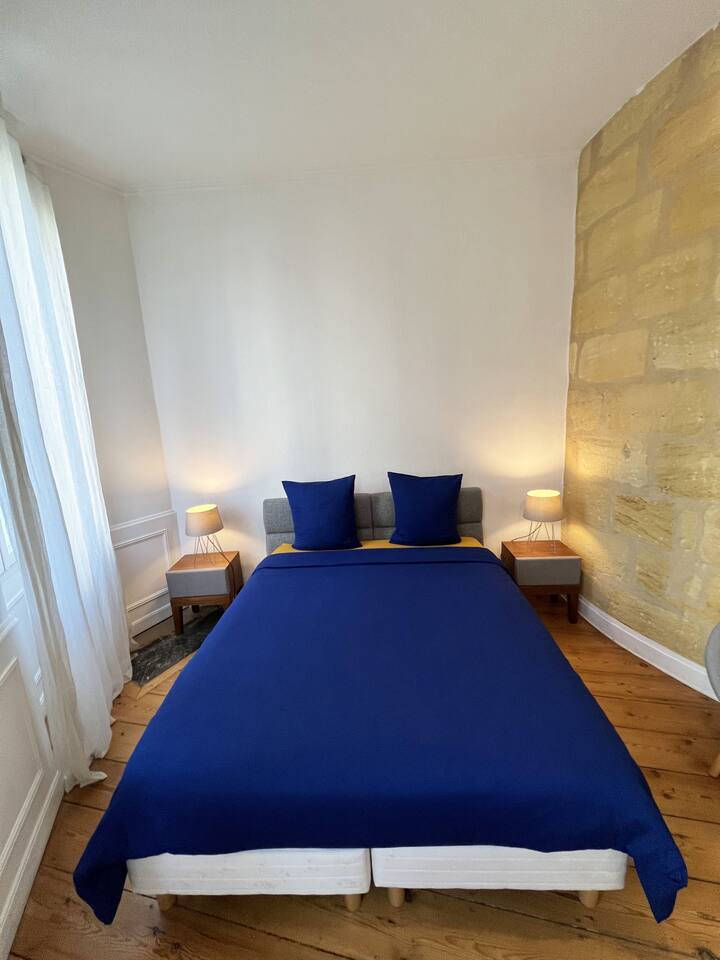 غرفة النوم الأولى التي تبلغ مساحتها حوالي 16 مترًا مربعًا مع جدارها الدائري الكبير من حجر جيروندين (السرير 160 × 200 )/ الغرفة الأولى (172 قدمًا مربعًا) مع جدارها الحجري المستدير الكبير في بوردو
