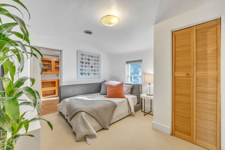 Მთავარი იატაკის საძინებელი სრული ზომის საწოლით ჭკვიანი ტელევიზორითა და კომფორტული სამკითხველო სკამით