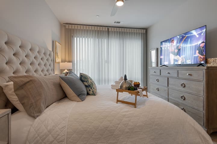 Wake up to natural light in this elegant bedroom with plush bedding and balcony access. A serene retreat for mornings in the heart of Nashville.